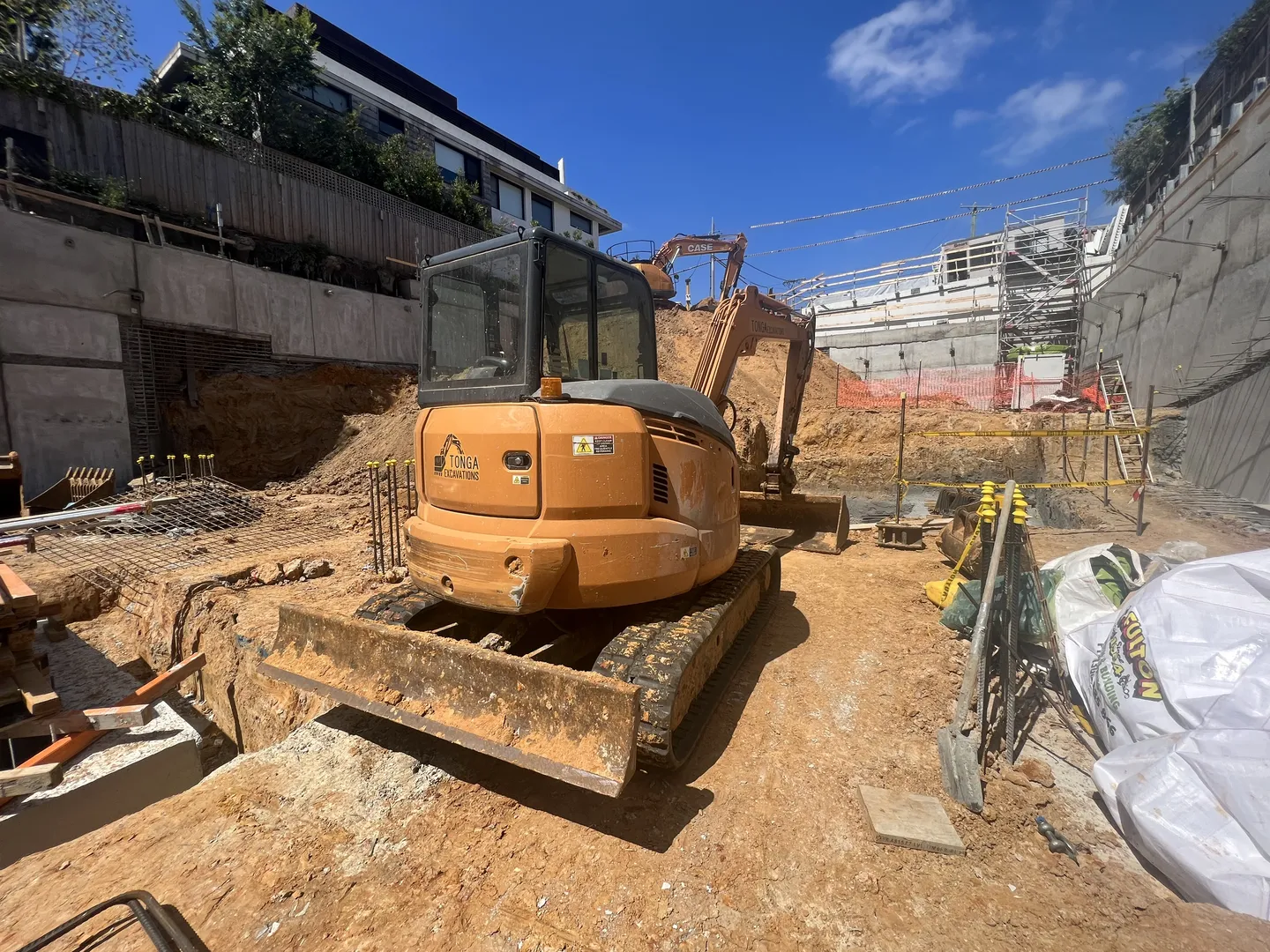 Backhoe at construction site with building and sky