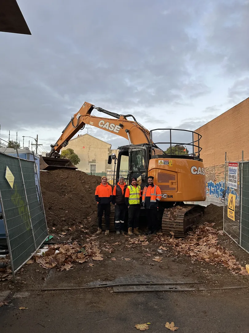 Construction crew with excavator on site.